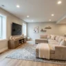 How to convert a basement into a living space – featured image of a finished basement with seating, TV, rug, plant, and egress window.