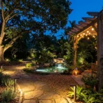 How to light a garden for evenings and entertaining – featured image showing path lights, uplighting, string lights, lanterns, and pond lighting.