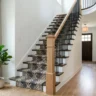 How to update a dated staircase without replacing it – featured image of a transformed staircase with white risers, stained treads, iron balusters, stair runner, and modern newel.