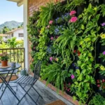 Vertical garden wall ideas for small spaces – featured image of a lush modular vertical garden on a small balcony with trailing plants and flowers.