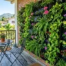 Vertical garden wall ideas for small spaces – featured image of a lush modular vertical garden on a small balcony with trailing plants and flowers.