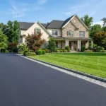 How to edge a driveway like a pro – featured image of a driveway with crisp Belgian block edging and a lush green lawn.