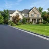 How to edge a driveway like a pro – featured image of a driveway with crisp Belgian block edging and a lush green lawn.